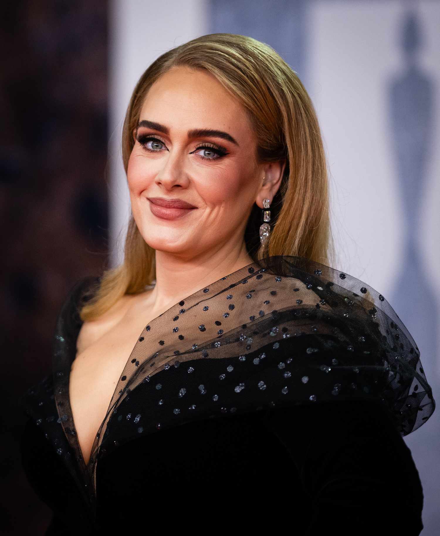 Adele with long, straight blonde hair in a black gown