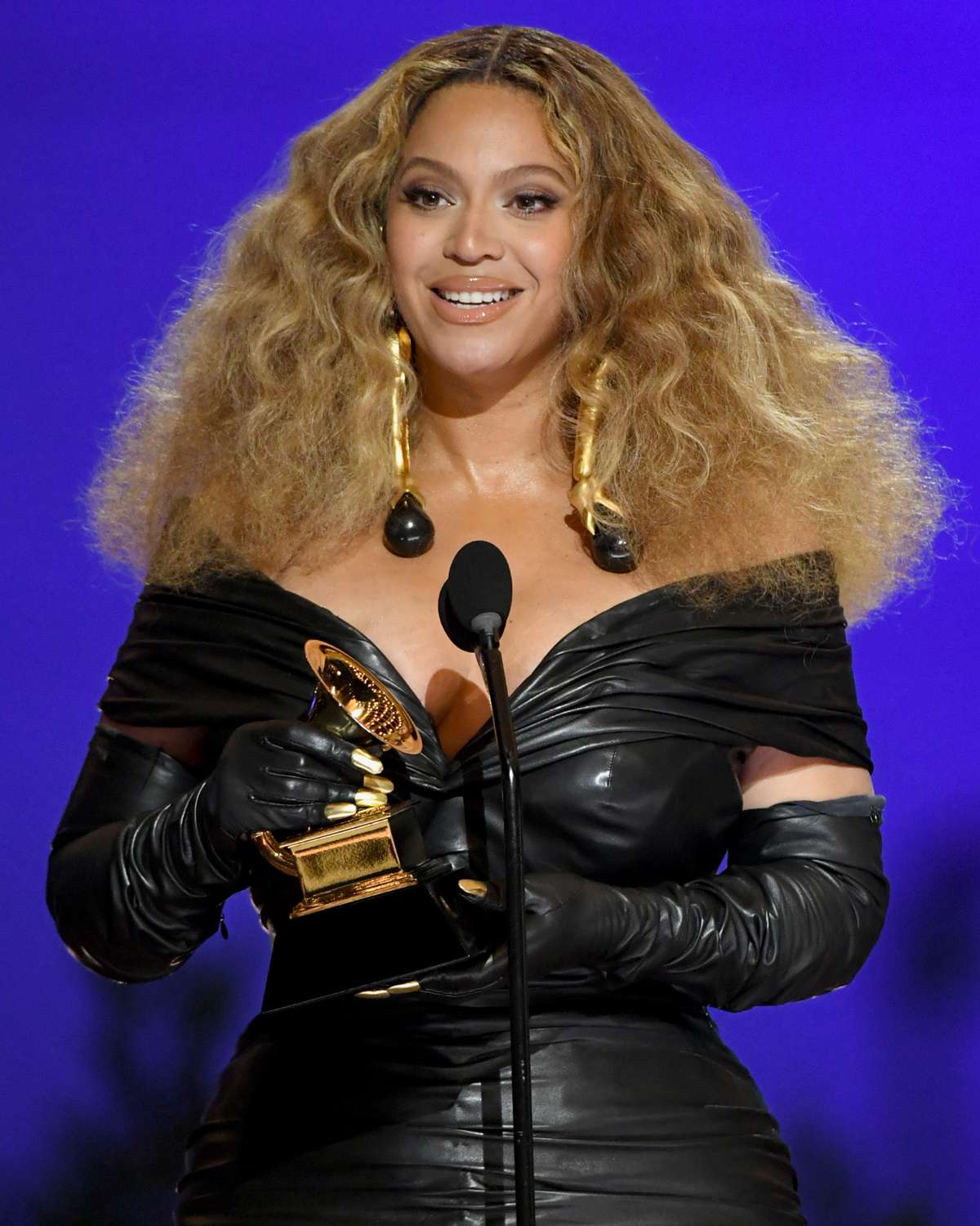Beyoncé wearing an off-the-shoulder black leather dress with matching gloves