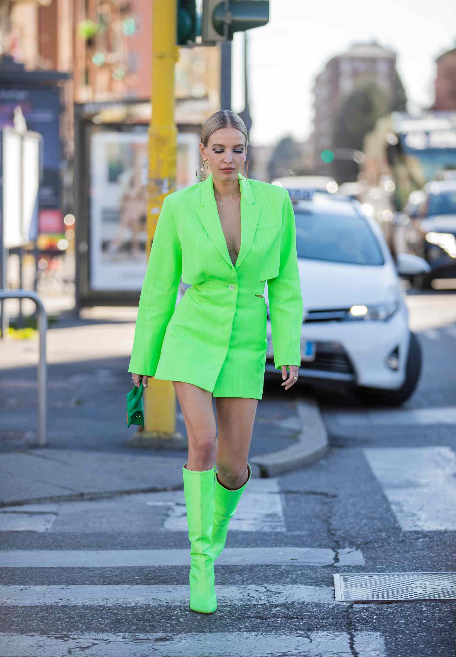 Person wearing a neon green blazer dress with matching knee-high boots
