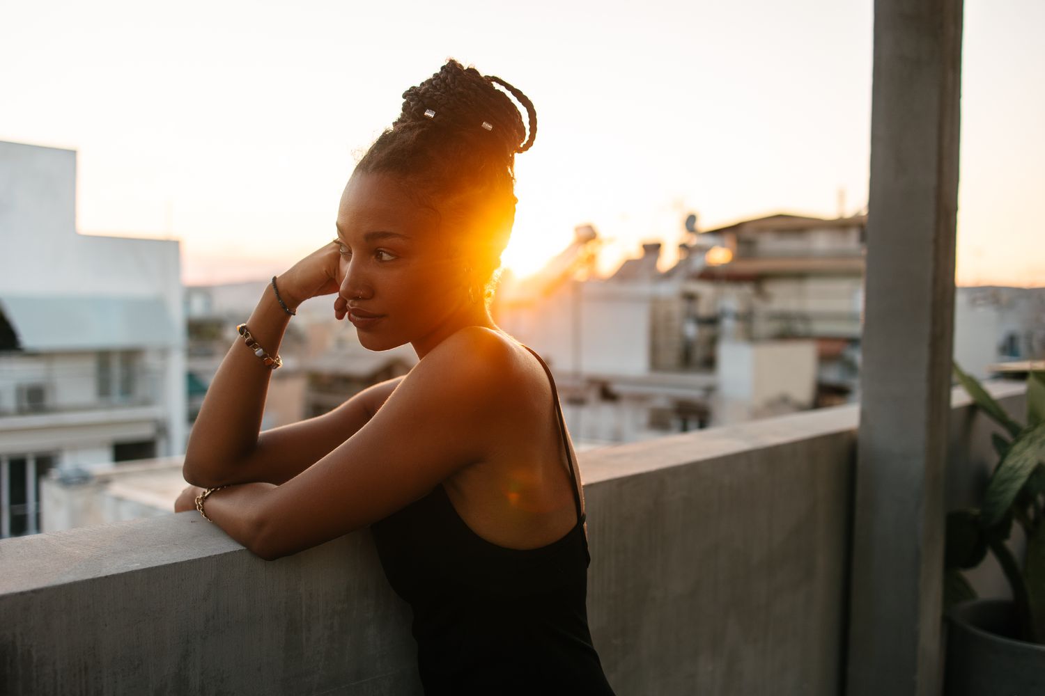Woman outside looking off the side while cast in sunset lighting