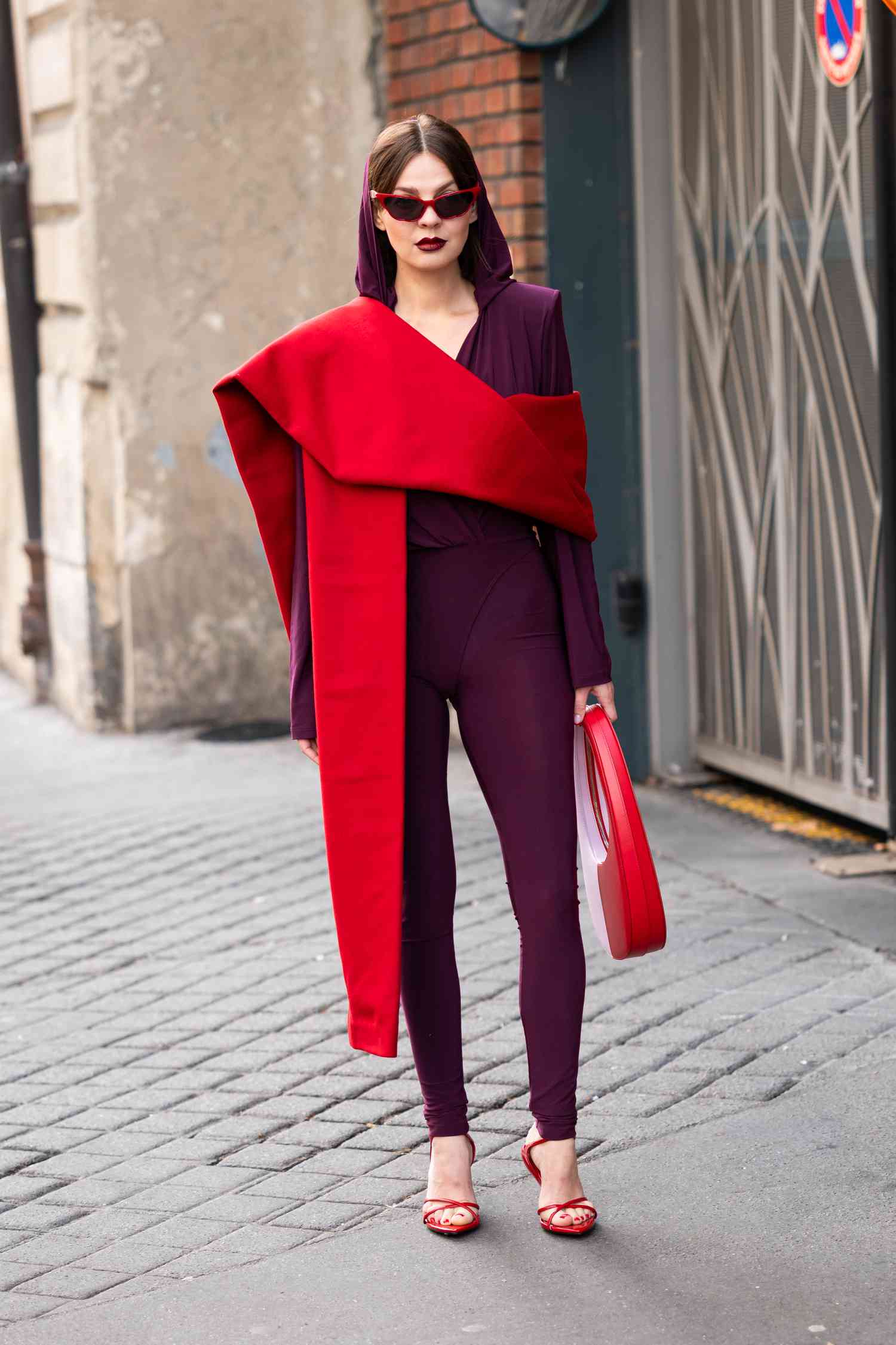 A woman wears a dark purple jumpsuit, a 2023 Scorpio outfit for women.