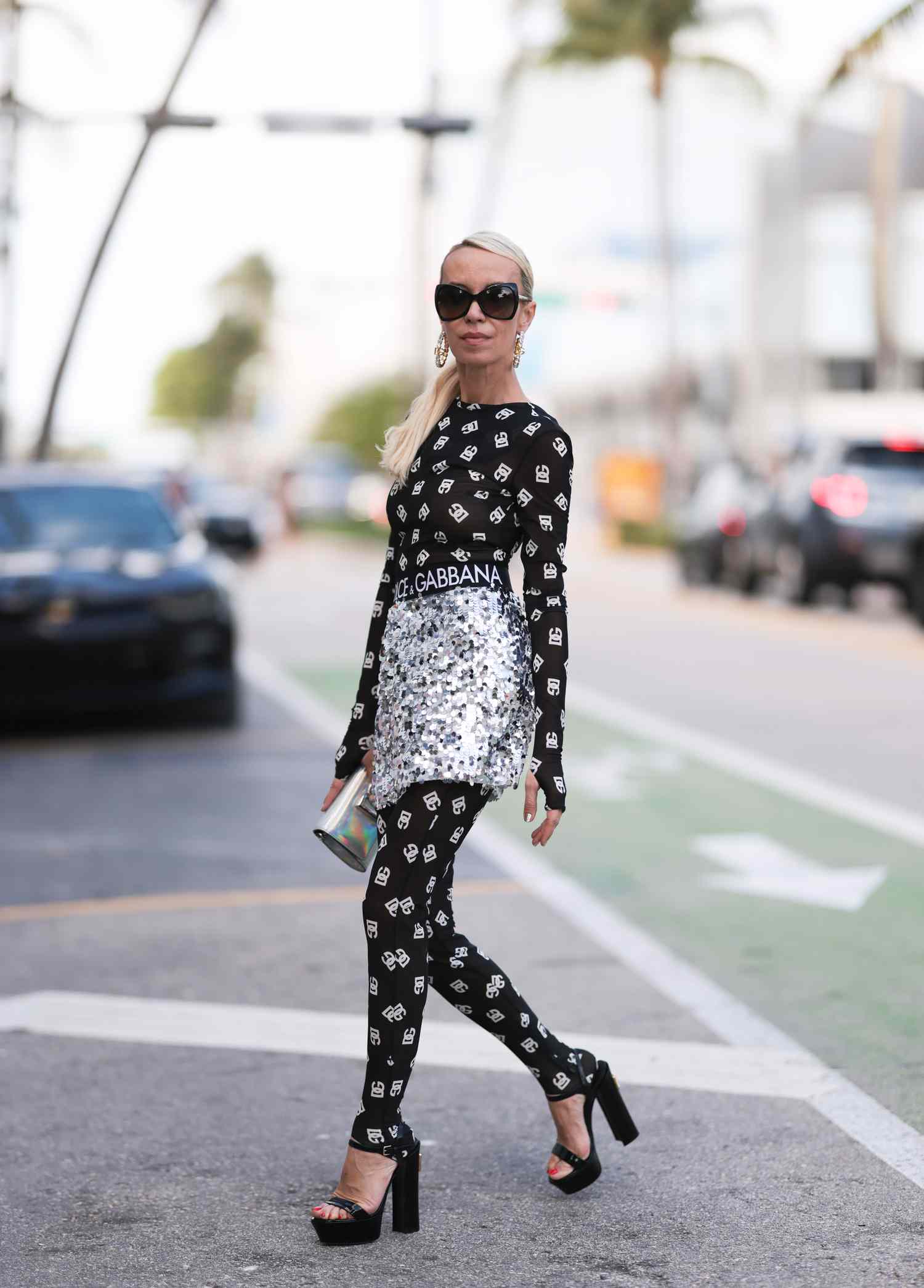 Person wearing a Dolce & Gabbana monogrammed outfit with silver sequined skirt