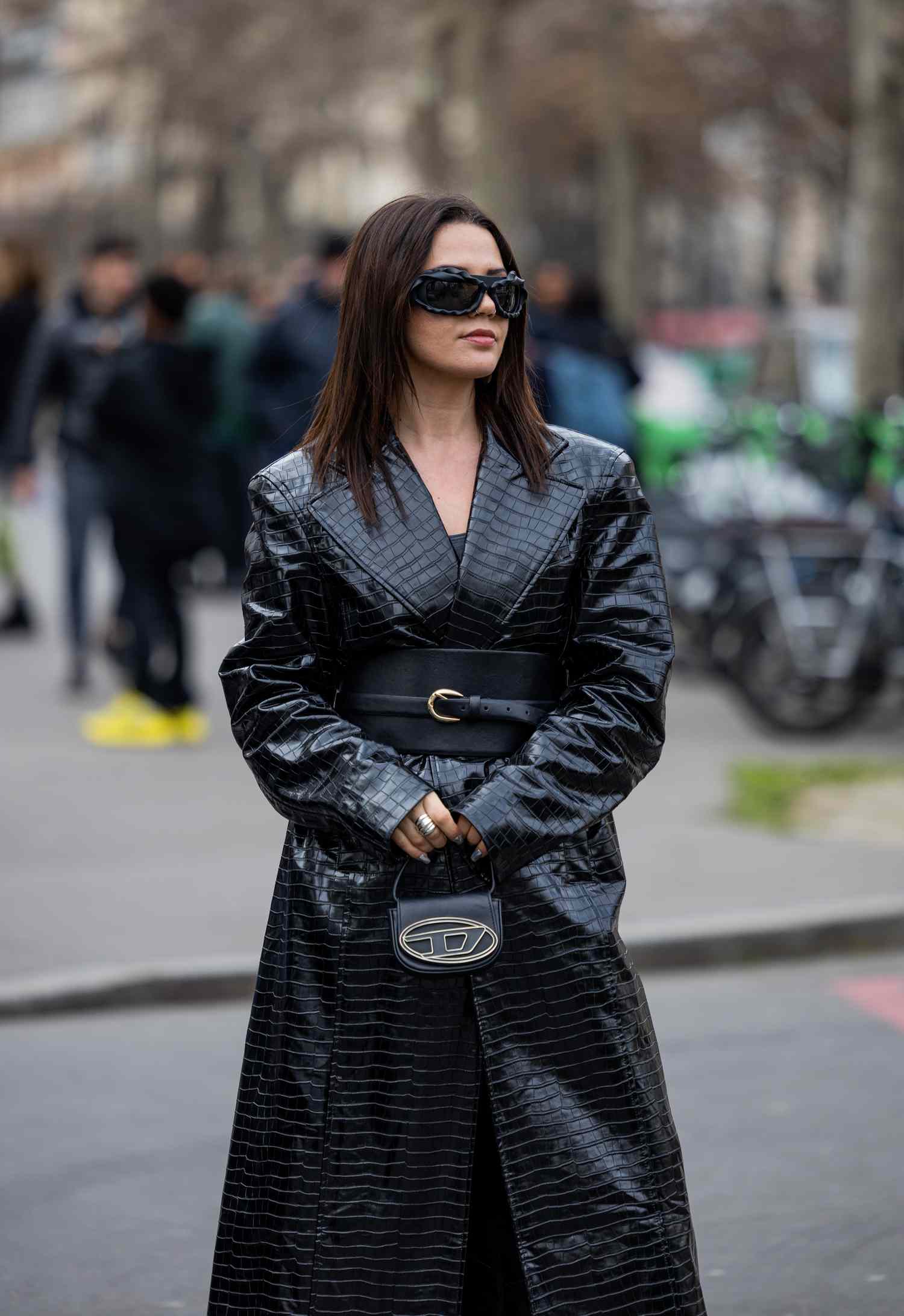 Amelie Stanescu wears a corset belt over a coat, a 2023 Scorpio outfit idea for women.