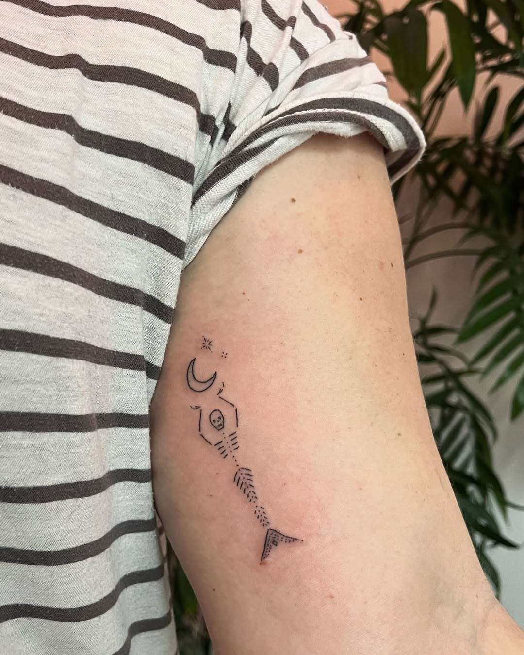 A skeleton mermaid holding up a moon