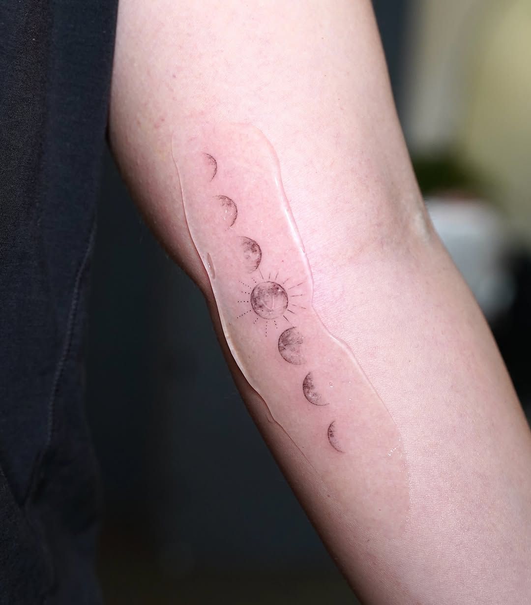 A tattoo showing the full lunar cycle