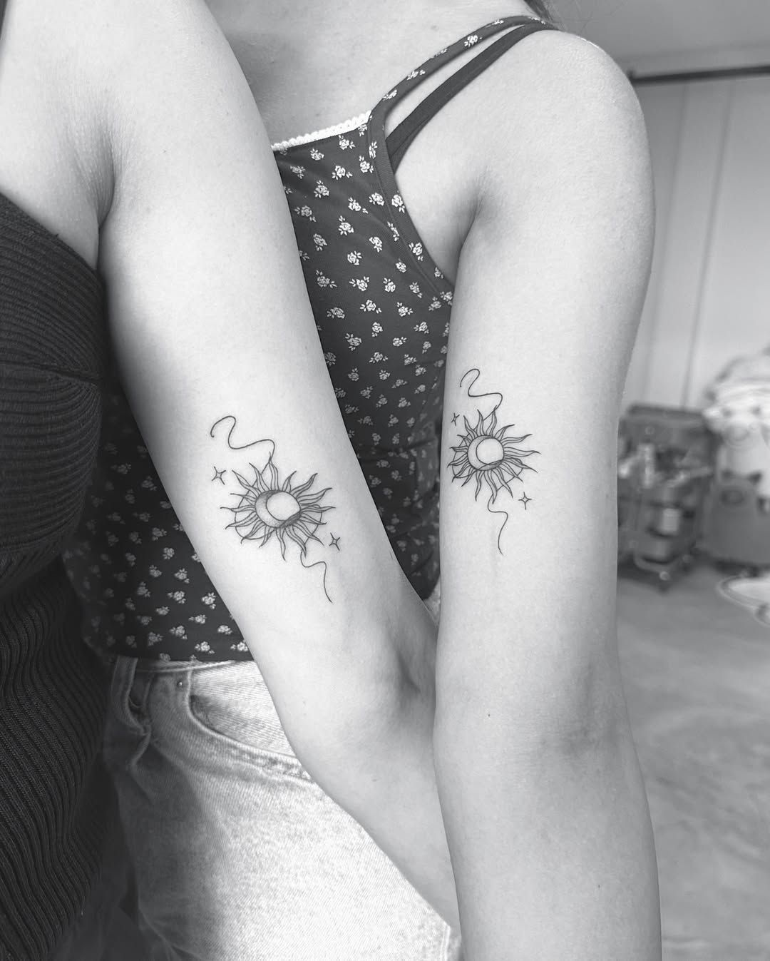 Two matching tattoos, of a moon and sun together