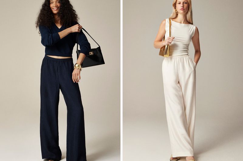 Two women modeling outfits, one in a dark outfit with a bag and another in a light outfit holding a purse