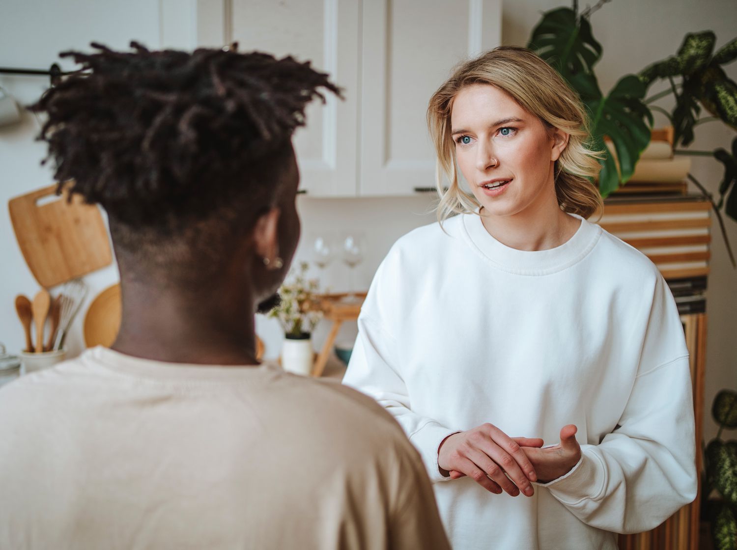 Two people having a conversation in a kitchen