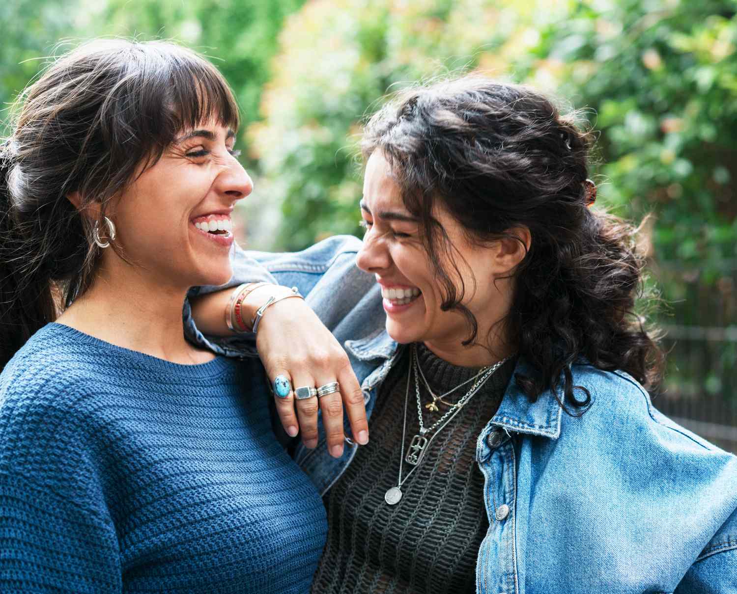 Two people outdoors smiling and interacting with each other