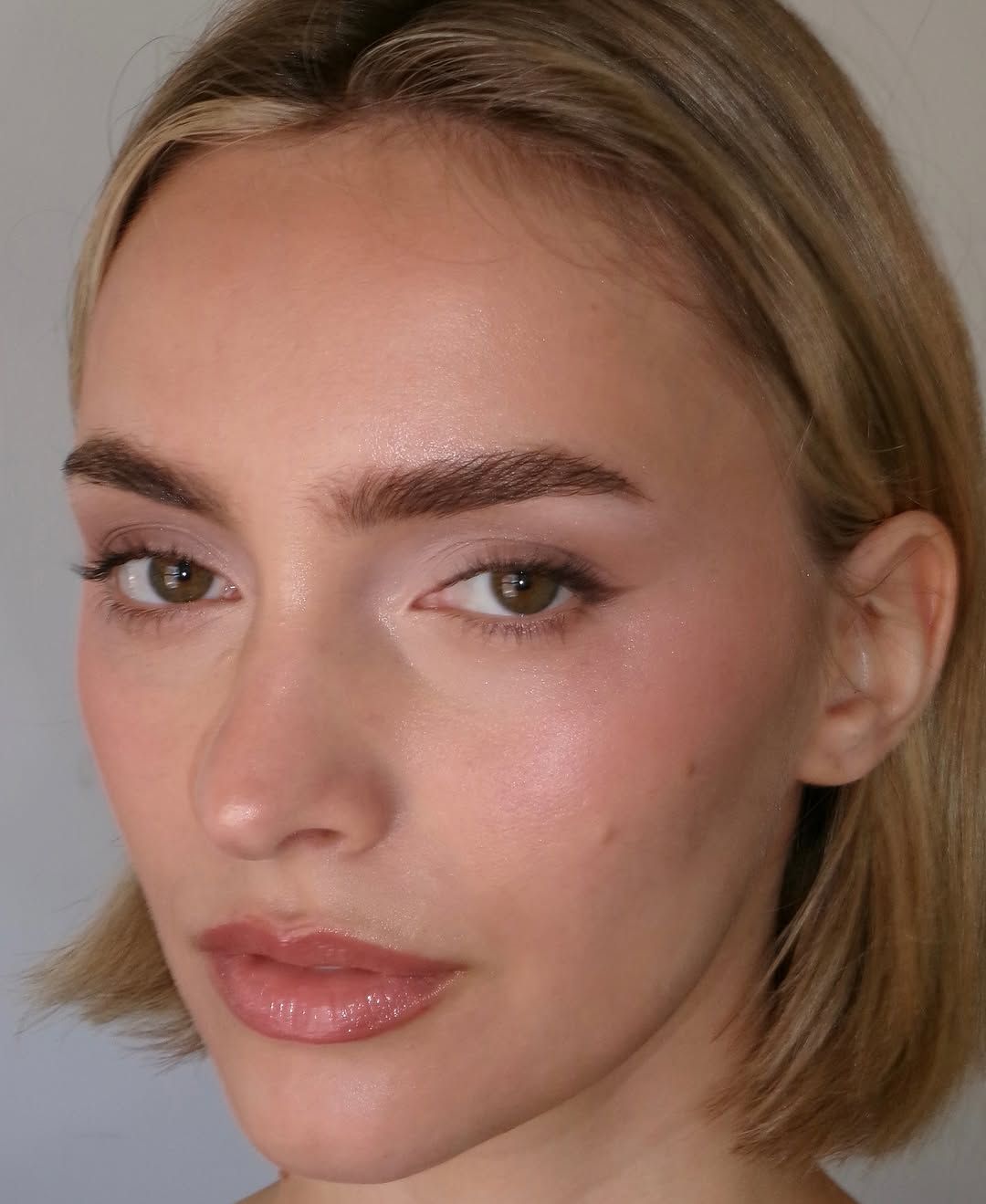 Close up of a person with chin length blonde hair and fluffy eyebrows