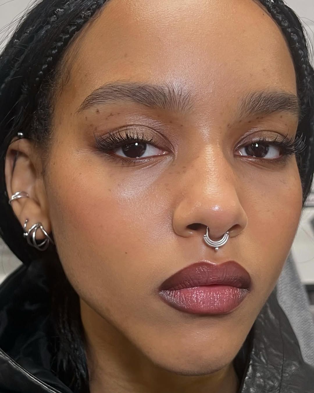Close up of a woman with dark lipstick and a nose ring