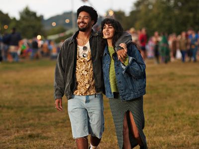 Couple holding hands and walking around a music festival