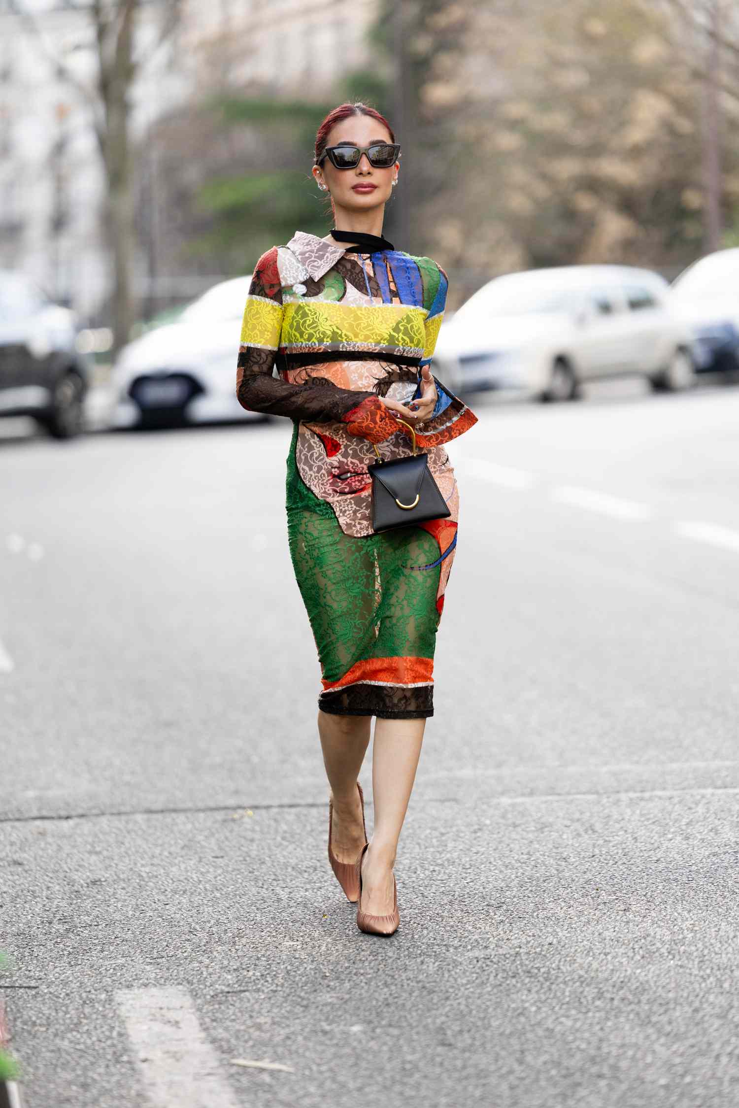 Heart Evangelista with her hair up wearing black sunglasses and a bold pattern mididress