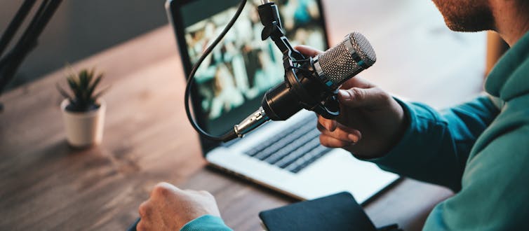 A man recording a podcast with a microphone and computer