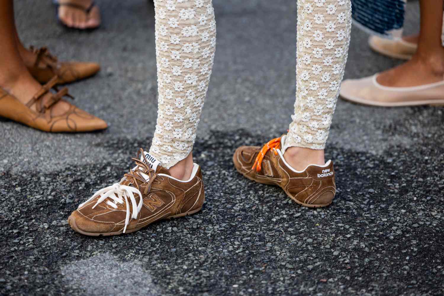 Closeup of unique footwear including sneakers and patterned leggings showcasing an eclectic fashion style