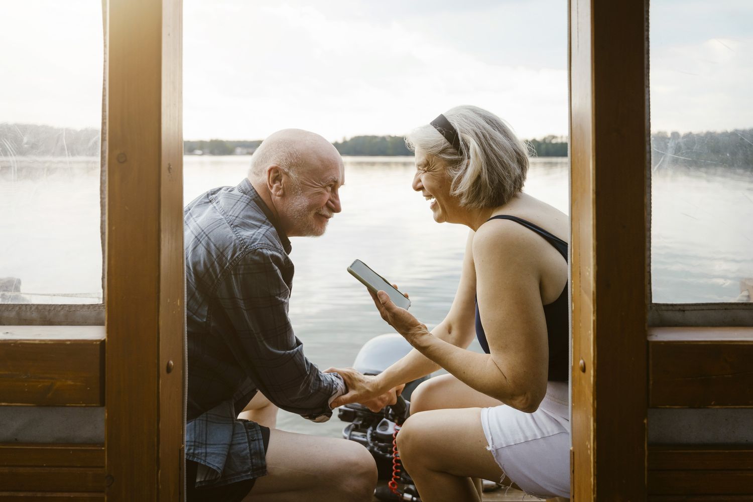 Couple sitting on a doc holding hands