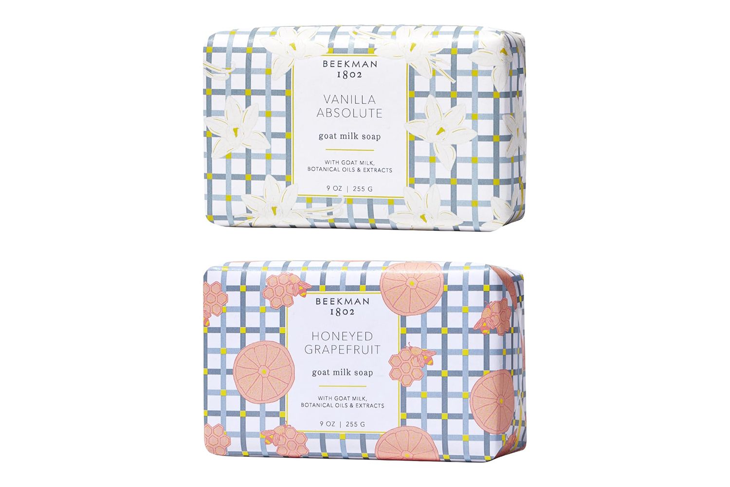 Two Beekman 1802 goat milk soap bars one labeled Vanilla Absolute and the other Honeyed Grapefruit showcasing the product packaging